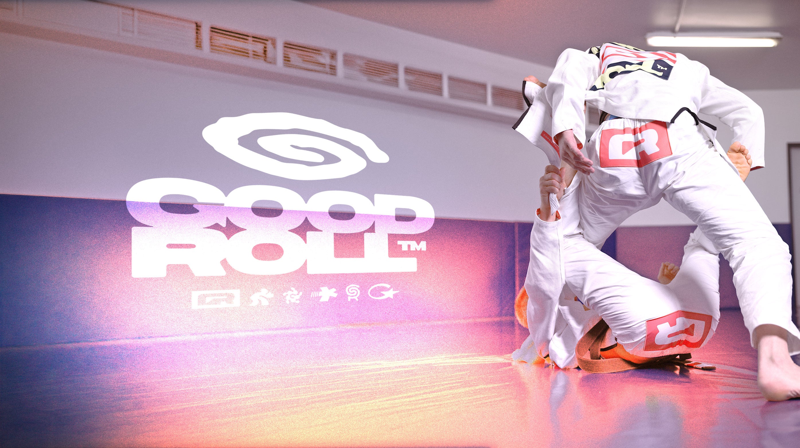 "Goodroll" lettering, with two BJJ practitioners next to it rolling in their Goodroll Heritage Gi